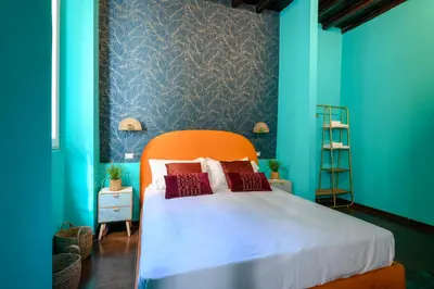 a bedroom with a bed with an orange headboard and blue walls at Riad Campo de' Fiori in Rome