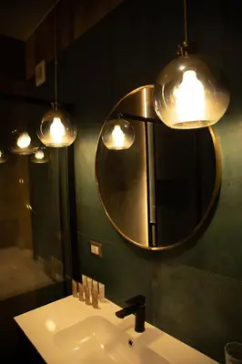 a bathroom with a sink and a mirror and lights at Riad Campo de' Fiori in Rome