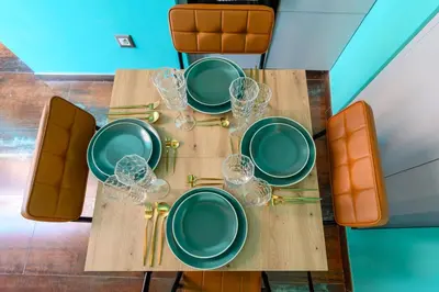 a table with green plates and wine glasses on it at Riad Campo de' Fiori in Rome