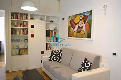 a living room with a couch and a book shelf at Your Roman Retreat near San Giovanni in Rome