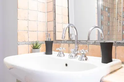 a white sink with two faucets in a bathroom at Mosaic Trastevere Silver Apartment in Rome
