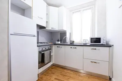 a kitchen with white cabinets and a microwave at Mosaic Trastevere Silver Apartment in Rome