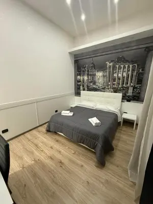 a bedroom with a bed with a black and white wall at FRALE Home in Rome in Rome