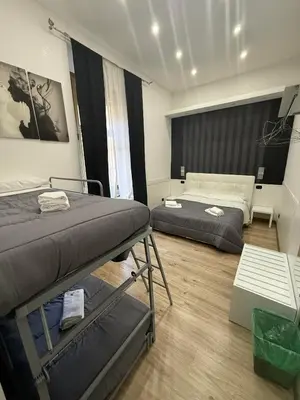 a room with two beds and a table in it at FRALE Home in Rome in Rome