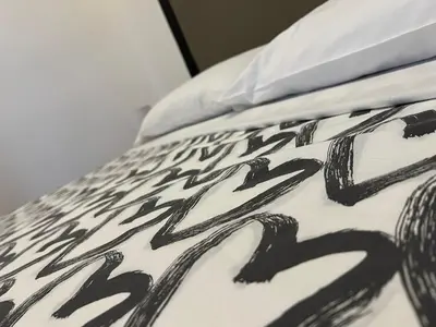 a bed with black and white sheets and a pillow at FRALE Home in Rome in Rome