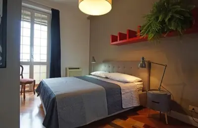 a bedroom with a bed and a lamp in it at Dimora Qeeboo in Rome