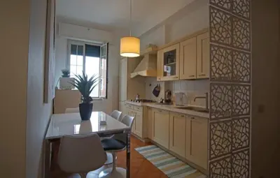 a kitchen with a table and chairs and a window at Dimora Qeeboo in Rome