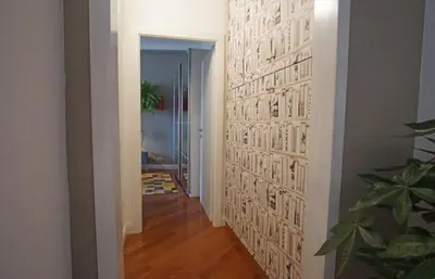 a hallway with a wall covered in white paper at Dimora Qeeboo in Rome