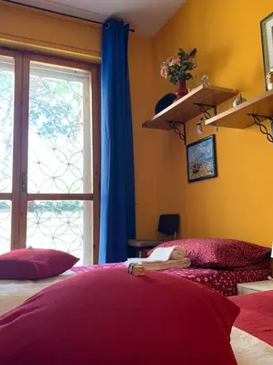 a bedroom with a bed with purple pillows and a window at LunaBed Roma - Affitti brevi in Rome