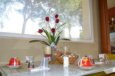 a table with red roses in a vase on it at LunaBed Roma - Affitti brevi in Rome