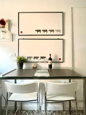 a glass table with two white chairs and a bottle of wine at Fabiola Holiday House in Rome