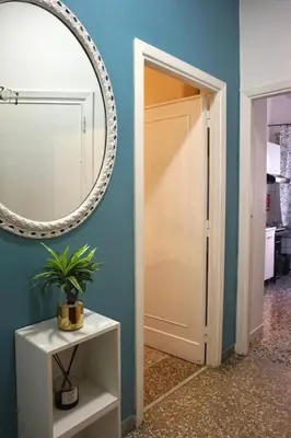 a mirror on a blue wall next to a door at Fabiola Holiday House in Rome