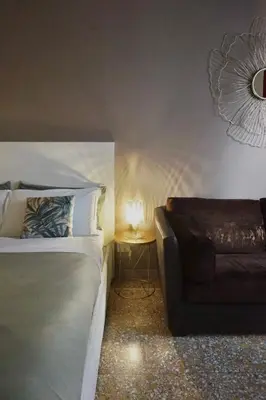 a bedroom with a bed and a couch and a lamp at Fabiola Holiday House in Rome