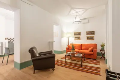 a living room with an orange couch and a chair at Popolo Charming Apartment in Rome