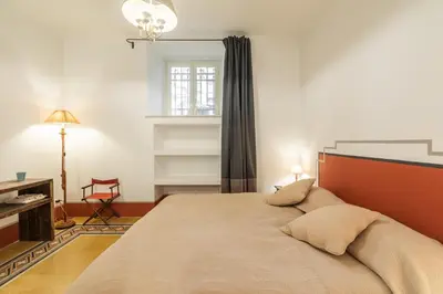a bedroom with a bed and a desk and a window at Popolo Charming Apartment in Rome