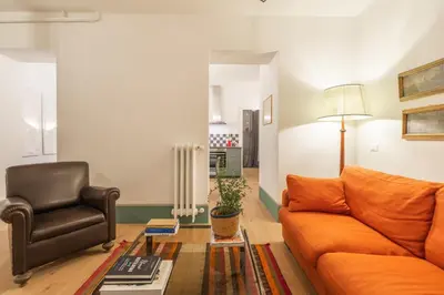 a living room with an orange couch and a chair at Popolo Charming Apartment in Rome