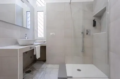 a white bathroom with a sink and a shower at APT Rome 5 BDRMs in Rome