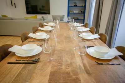 a long wooden table with plates and glasses on it at APT Rome 5 BDRMs in Rome
