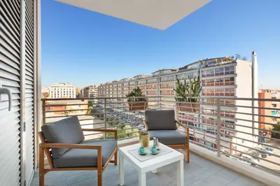 two chairs and a table on a balcony with a view at Trastevere Contemporary Apartment in Rome
