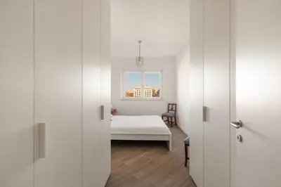 a white room with a bed and a window at Trastevere Contemporary Apartment in Rome