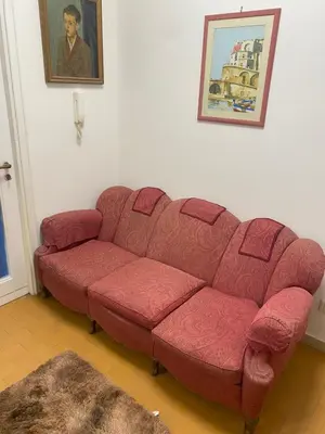 a red couch sitting in a living room at Nic Roma House in Rome