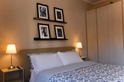 a bedroom with a bed with three pictures on the wall at Domus Oriana in Rome