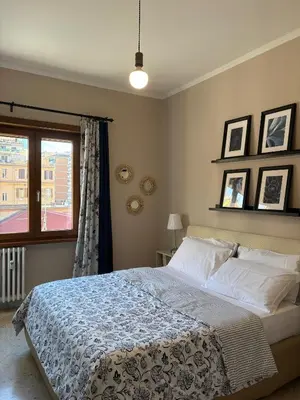 a bedroom with a large bed and a window at Domus Oriana in Rome
