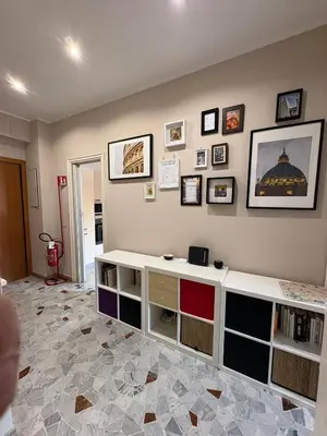 a room with a wall with many pictures on it at Domus Oriana in Rome