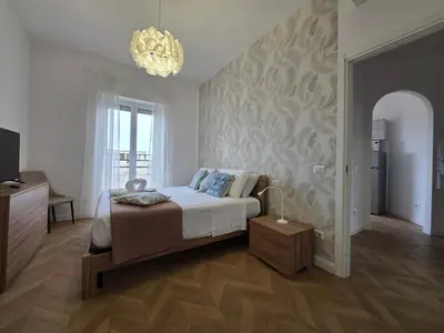a bedroom with a large bed and a chandelier at Trastevere Dreamer Home Rome in Rome