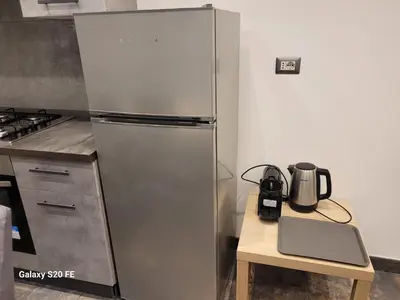 a stainless steel refrigerator in a kitchen with a table at Vatican house 98 in Rome