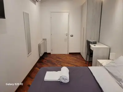 a bedroom with a bed and a desk with a towel at Vatican house 98 in Rome