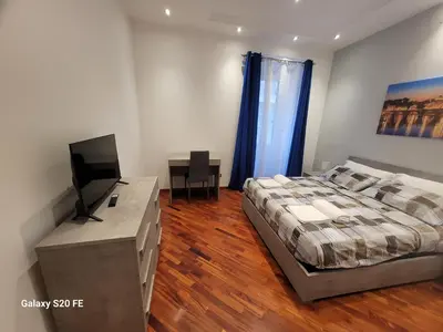 a bedroom with a bed and a desk with a television at Vatican house 98 in Rome