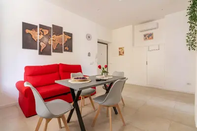 a living room with a red couch and a table at Domus Eroi in Rome