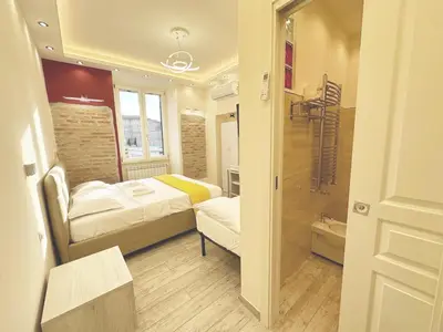 a small room with two beds and a bathroom at IMPERIUM INN in Rome