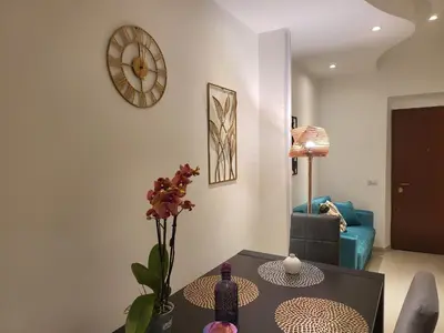 a living room with a table and a clock on the wall at Vatican Tolemaide 2 Suites 2 Bagni in Rome