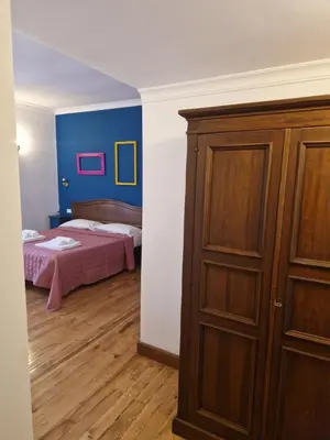 a bedroom with a bed and a wooden cabinet at Pepe's Place - Carlo Alberto in Rome