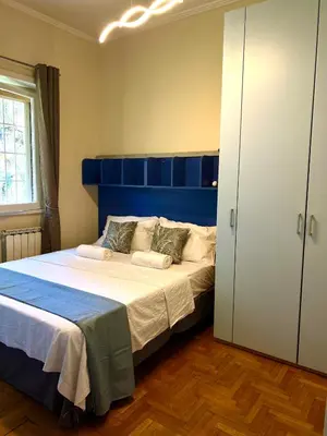 a bedroom with a large bed with a blue headboard at Luxury Giorgi Home in Rome