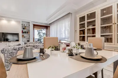 a dining room with a white table and chairs at Luxury Giorgi Home in Rome