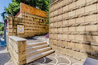a brick wall with stairs next to a building at Luxury Giorgi Home in Rome