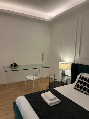 a bedroom with a bed and a desk with a chair at Luxury Suite Rialto in Rome