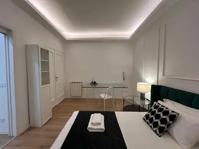 a bedroom with a bed and a table in it at Luxury Suite Rialto in Rome