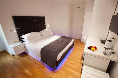 a bedroom with a large bed with a black headboard at Melody Suite Rome in Rome