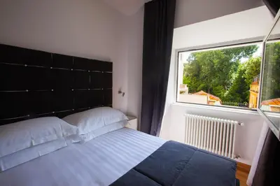 a bedroom with a bed and a large window at Melody Suite Rome in Rome