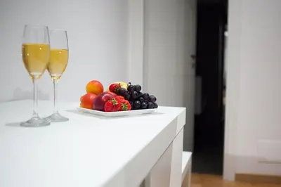 a plate of fruit and two glasses of champagne at Melody Suite Rome in Rome