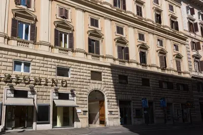 a large brick building with a sign on it at Melody Suite Rome in Rome