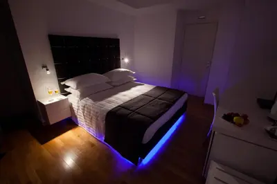 a bedroom with a bed with blue lights on it at Melody Suite Rome in Rome