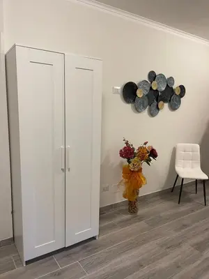 a room with a white cabinet and a vase with flowers at MARAND HOUSE ROME in Rome