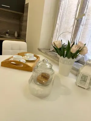 a table with a glass jar and a vase of flowers at MARAND HOUSE ROME in Rome