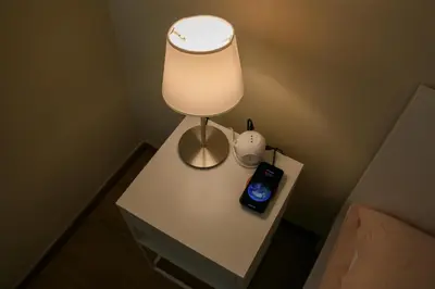 a table with a lamp and an alarm clock on it at Policlinico Apartment in Rome