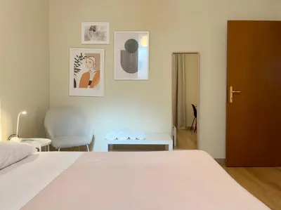a bedroom with a white bed and a chair at Policlinico Apartment in Rome